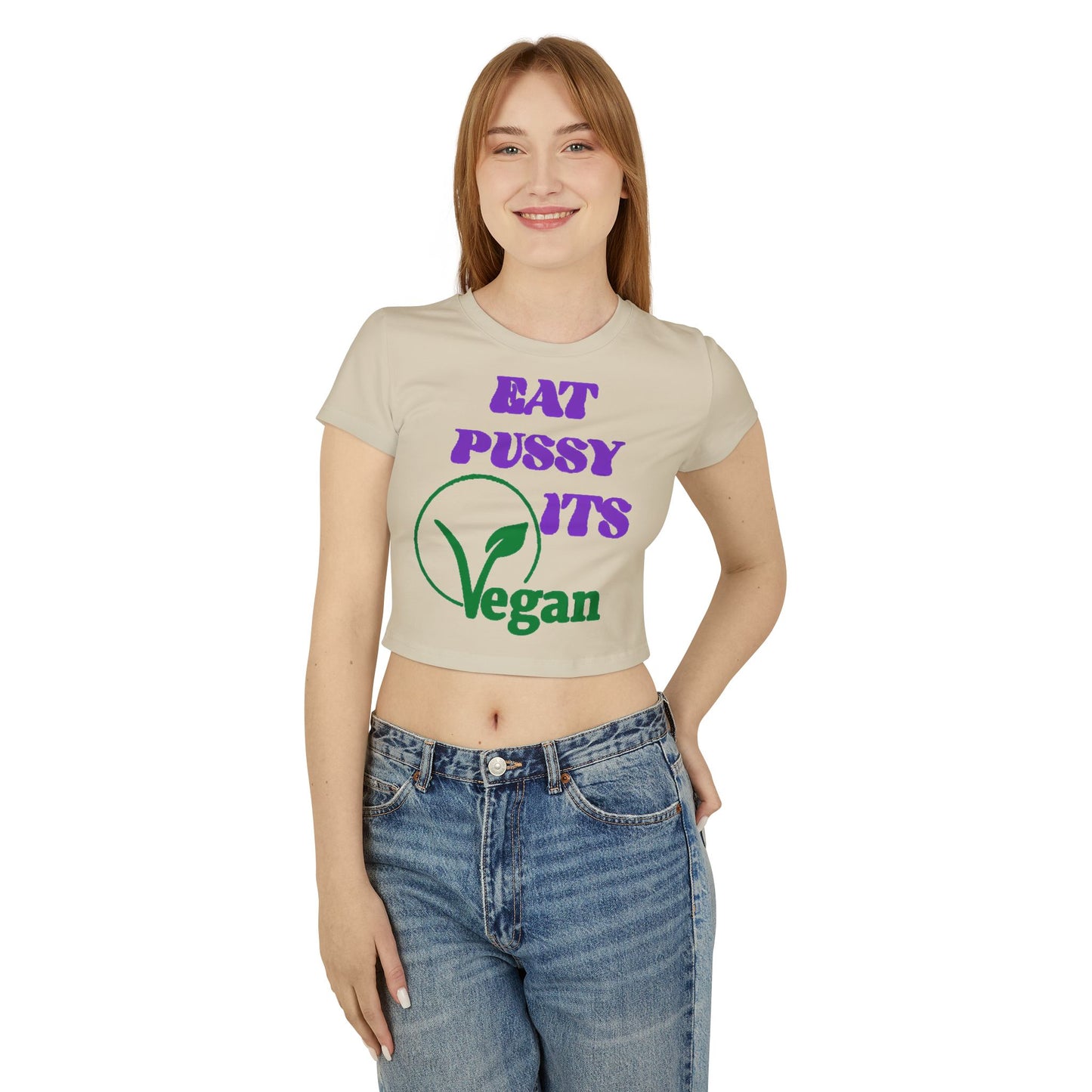 Stylish woman wearing a humorous cropped t-shirt with vegan-themed design, paired with high-waisted jeans, exuding confidence and playful vibes.
