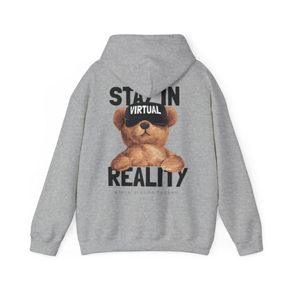 Chic grey hoodie adorned with a delightful teddy bear design wearing VR goggles, accompanied by the striking phrase 'STAY IN VIRTUAL REALITY', embodying both style and warmth.