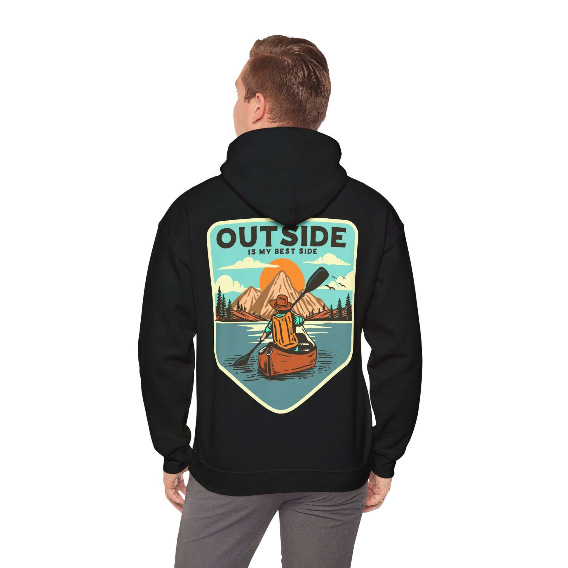 Stylish black hoodie showcased on a model from the back, featuring a captivating illustration of a kayaker against a stunning mountain backdrop and the phrase 'OUTSIDE IS MY BEST SIDE'.