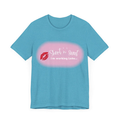 Striking front view of the Sabrina Carpenter Inspired Unisex Short Sleeve Tee featuring a vibrant lipstick print and the phrase 'Short 'n' sweet, I'm working late...',