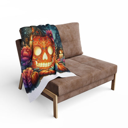 Luxurious Decorative and Warm Halloween Spooky Arctic Fleece Blanket draped over a stylish brown sofa, showcasing a vibrant skull design adorned with flowers and candles.
