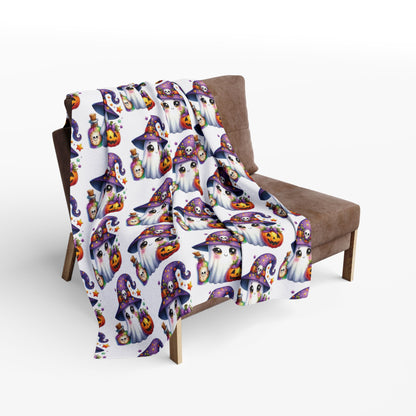 Decorative and Warm Halloween Cute Arctic Fleece Blanket draped over a chair, featuring vibrant ghost and Halloween-themed motifs for a festive touch.