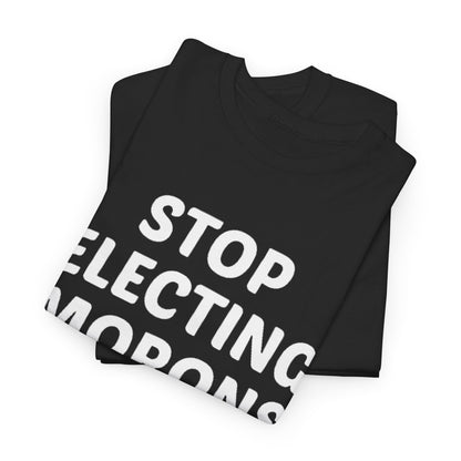 Chic folded unisex t-shirts featuring the striking phrase 'Stop Electing Morons' in large, white font, embodying a blend of humour and sophistication ideal for thoughtful individuals.