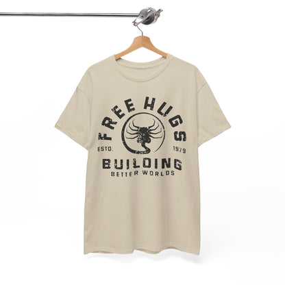 Sophisticated beige men's t-shirt displayed on a wooden hanger, featuring a vintage-inspired 'Free Hugs' and 'Building Better Worlds' text emblem.