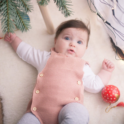 Baby Girl in a Stylish Cotton Romper, showcasing all-season comfort for Spring, Autumn & Winter, lying on a soft surface with decorative elements.