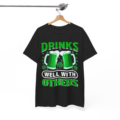 Elegant display of a Funny St. Patrick's Day Unisex T-Shirt hanging with 'Drinks Well With Others' and vibrant green beer mugs, ideal for luxurious celebrations.