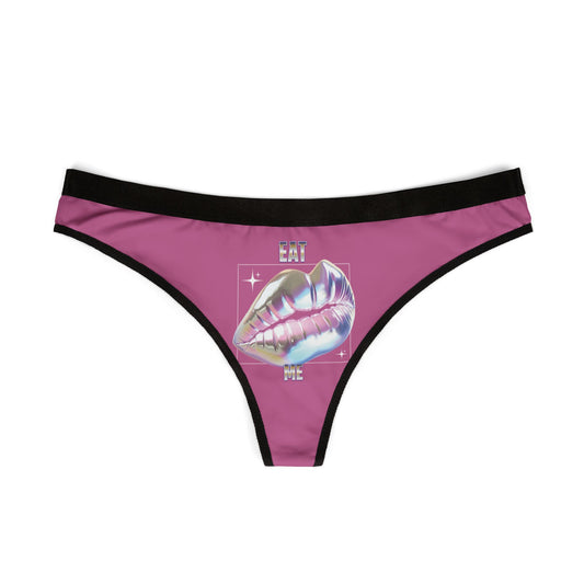 Elegant thong showcasing a glossy holographic lip graphic with the wording 'EAT ME', rendered in a chic pink tone with contrasting black trim.