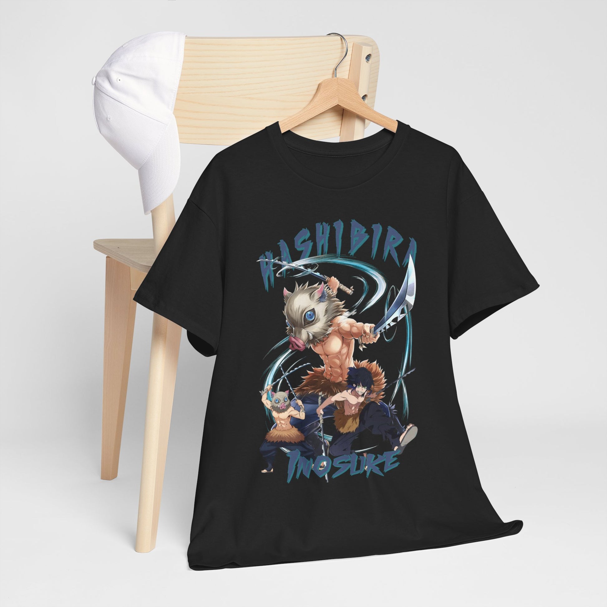 Sophisticated black t-shirt draped on a wooden chair next to a cap, featuring a vibrant anime design that embodies adventure and bold fashion.