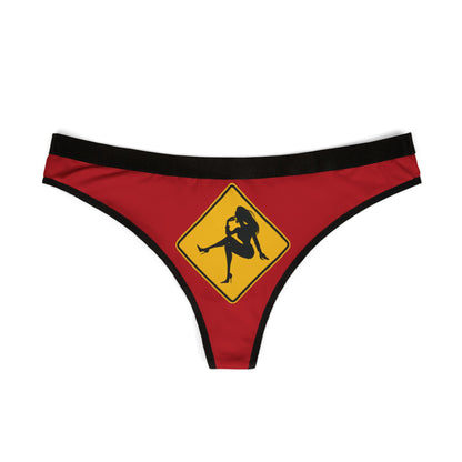 Stylish women's thong in rich red with a striking yellow caution sign graphic, embodying a humorous and flirty touch ideal for special celebrations.