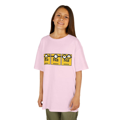 A girl happily wearing a pink Minions Kids T-Shirt featuring a fun periodic table design with Barium and Sodium. This vibrant T-shirt is a delightful choice for children who love science and the Minions, adding a playful touch to their wardrobe. T Shirt, Funny, Minions.