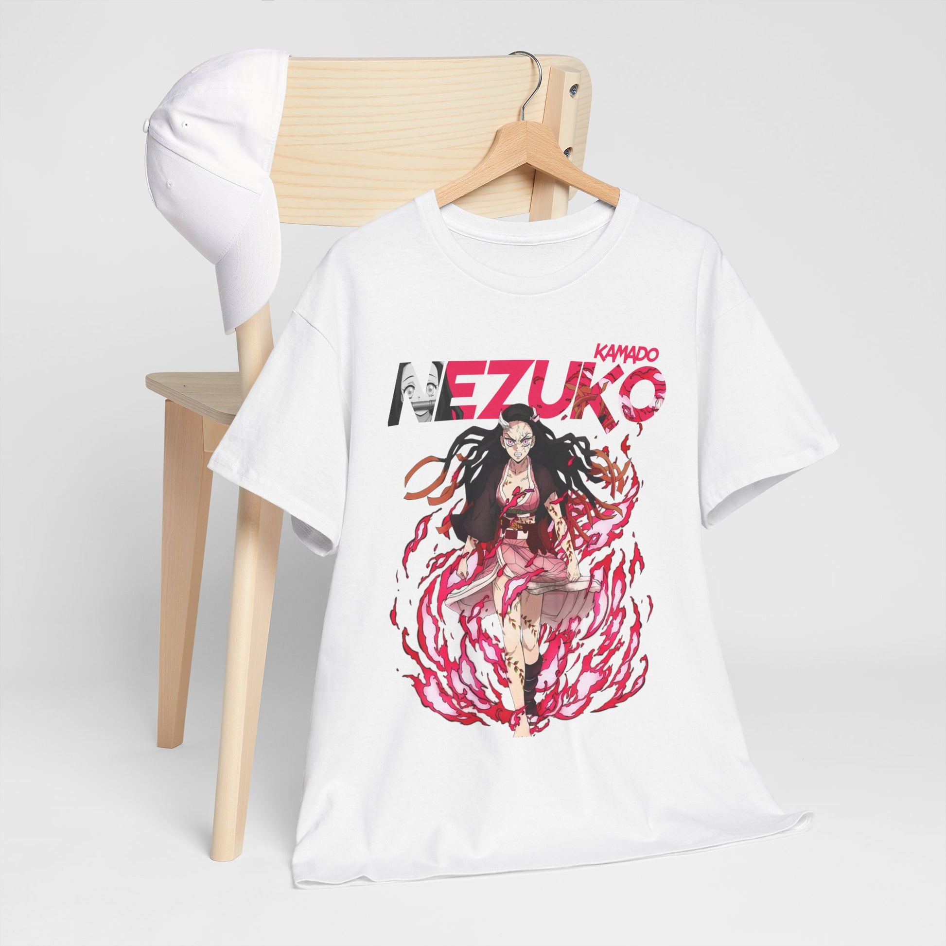 Chic arrangement of a Nezuko Kamado T-shirt paired with a white cap on a wooden chair, exuding a sophisticated anime-inspired lifestyle.