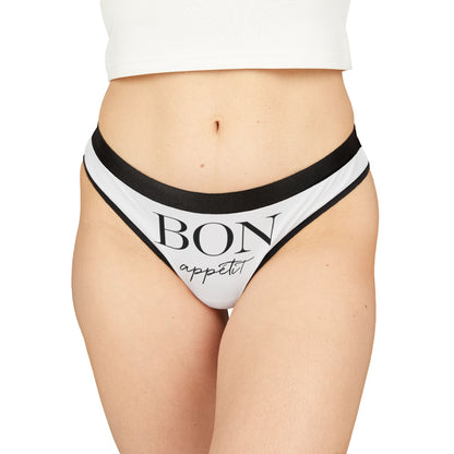 Luxury women's thong featuring 'BON appétit' in elegant lettering, designed with a chic black trim, perfect for adding a cheeky touch to intimate apparel.