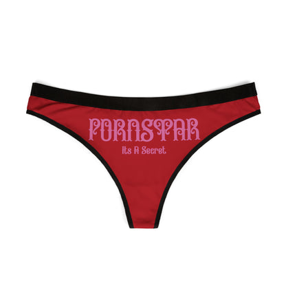 Front view of a striking red thong displaying the bold phrase 'PORNSTAR: It's a Secret', accented with a sleek black trim.