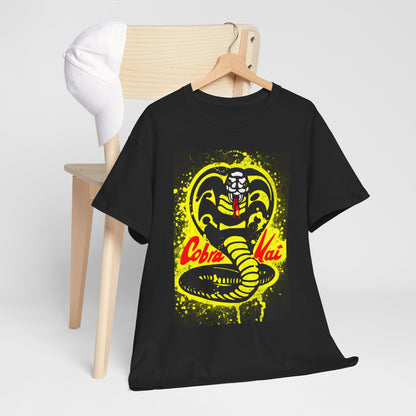 Chic black Cobra Kai T-shirt stylishly hung beside a minimalist wooden chair, showcasing an eye-catching graphic of a snake in rich yellow and red tones, perfect for casual elegance.