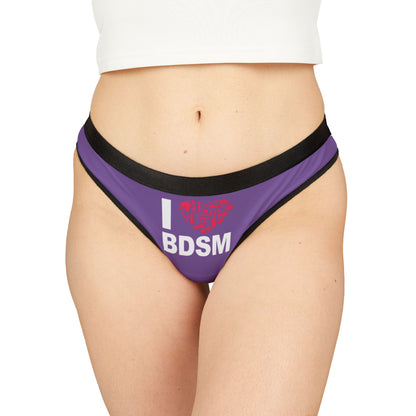 Luxurious women's thong in vibrant purple featuring a cheeky 'I love BDSM' graphic. Ideal for playful romantic occasions, this whimsical lingerie piece adds a touch of humour and allure to any intimate wardrobe.