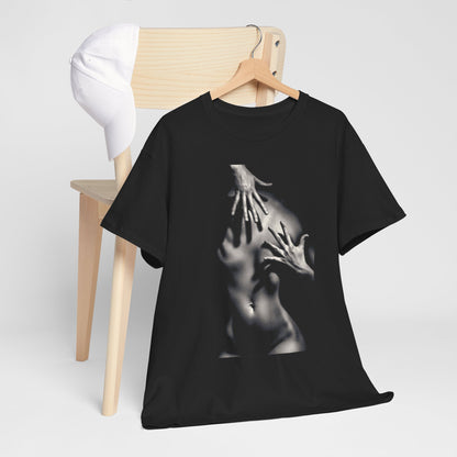 Elegant black cotton graphic t-shirt featuring an artistic design of hands on a silhouette, showcased on a wooden hanger beside a stylish white cap on a minimalist chair.