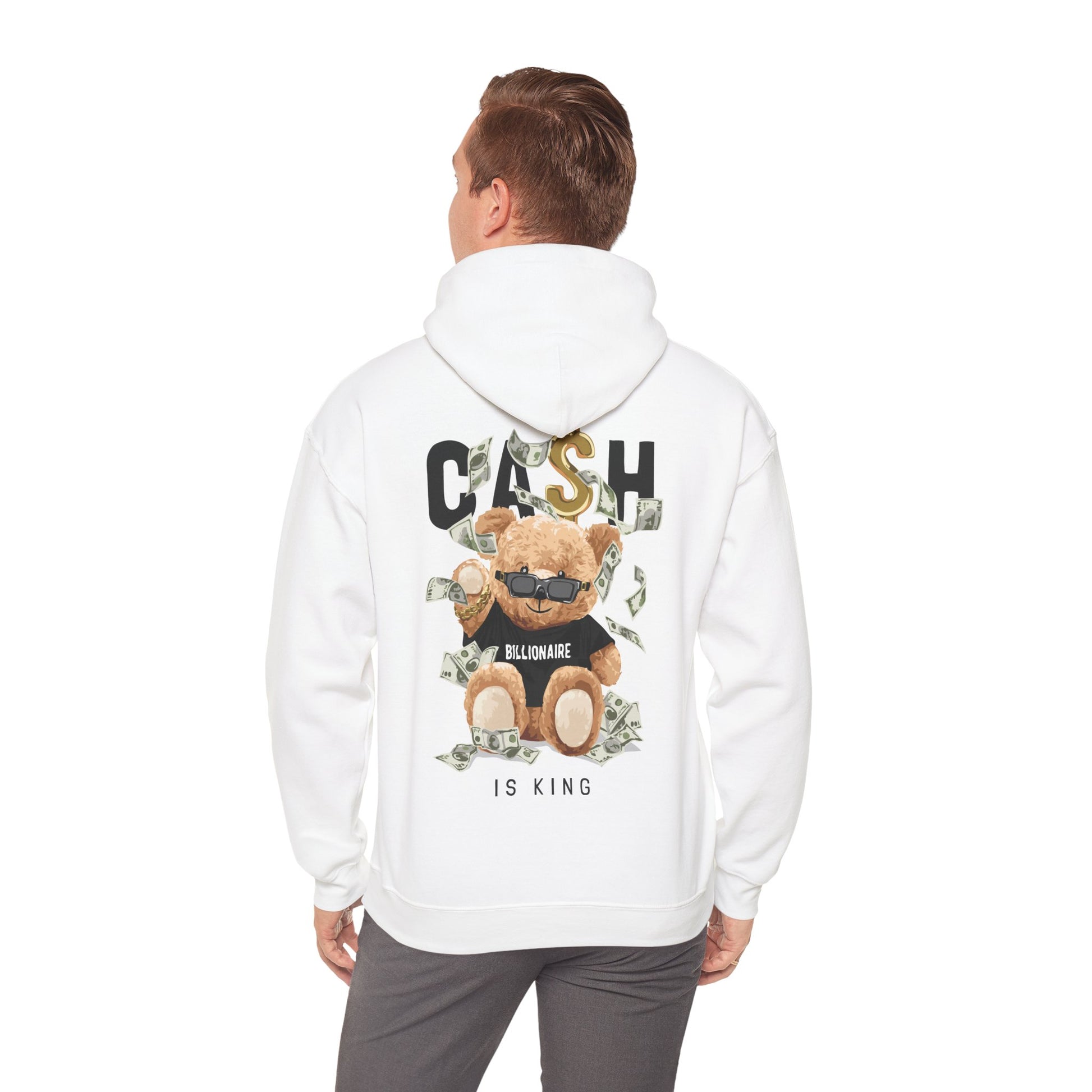 Man wearing a trendy white hoodie featuring a fun teddy bear graphic with dollar bills and the phrase 'CASH IS KING', stylishly highlighting casual elegance.