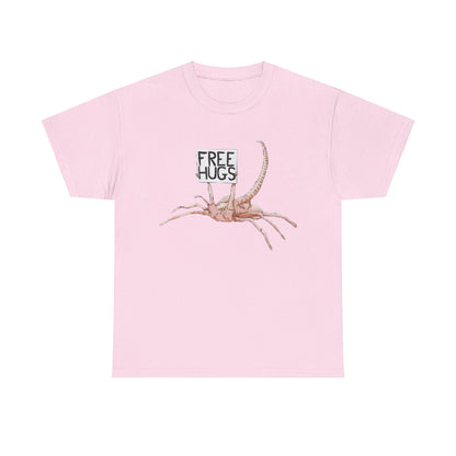 Stylish Alien Xenomorph Facehugger Free Hugs Graphic Unisex Tee Shirt in soft pink, decorated with a charming facehugger graphic holding a 'Free Hugs' sign.
