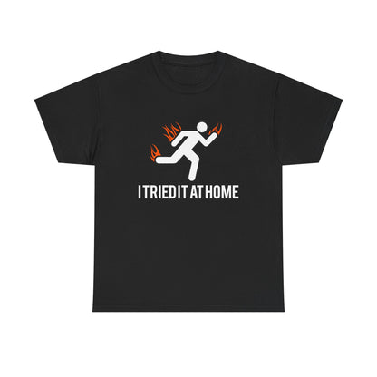 Luxury black mens t-shirt featuring a minimalist stick figure running design with vivid flames and the empowering phrase 'I TRIED IT AT HOME' highlighting movement and motivation.