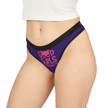 Close-up of a stylish woman wearing a purple thong with the phrase 'Good Girls Need Spanking Too', representing a blend of humour and intimate allure.