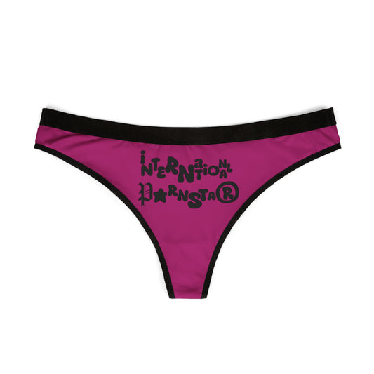 Front view of a stylish cheeky thong showcasing the unique 'International Star' design in bold lettering, set against a vibrant magenta background.