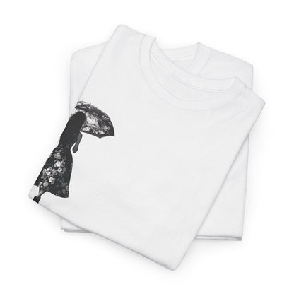 Duality Dreams Unisex Graphic T-Shirt neatly folded, displaying the elegant silhouette design featuring a woman with a floral umbrella for an artistic style.