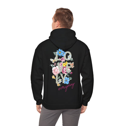 Elegant black hoodie worn by a model, displaying a floral back print with the word 'LOVELY' and butterflies, exuding a unique charm.