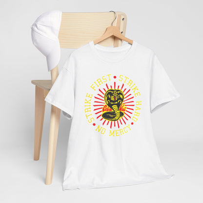Refined display of a Cobra Kai t-shirt resting on a minimalist chair, featuring a vibrant snake design and the powerful phrase 'Strike First, Strike Hard, No Mercy', embodying the essence of martial arts lifestyle.