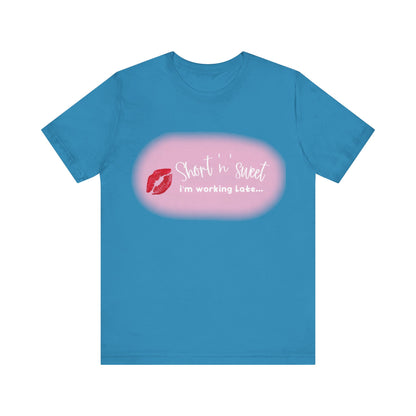 Sabrina Carpenter Inspired Unisex Short Sleeve Tee in vibrant blue, showcasing a stylish lipstick print with the phrase 'Short 'n' sweet, I'm working Late...' perfect for making a fashionable statement.