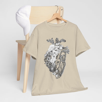 Floral heart graphic t-shirt elegantly draped over a chair next to a crisp white cap, combining artistic design with casual luxury.