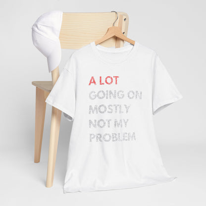 Men's luxury white t-shirt featuring a humorous graphic design that reads 'A LOT GOING ON MOSTLY NOT MY PROBLEM', elegantly displayed on a wooden hanger beside a stylish cap.