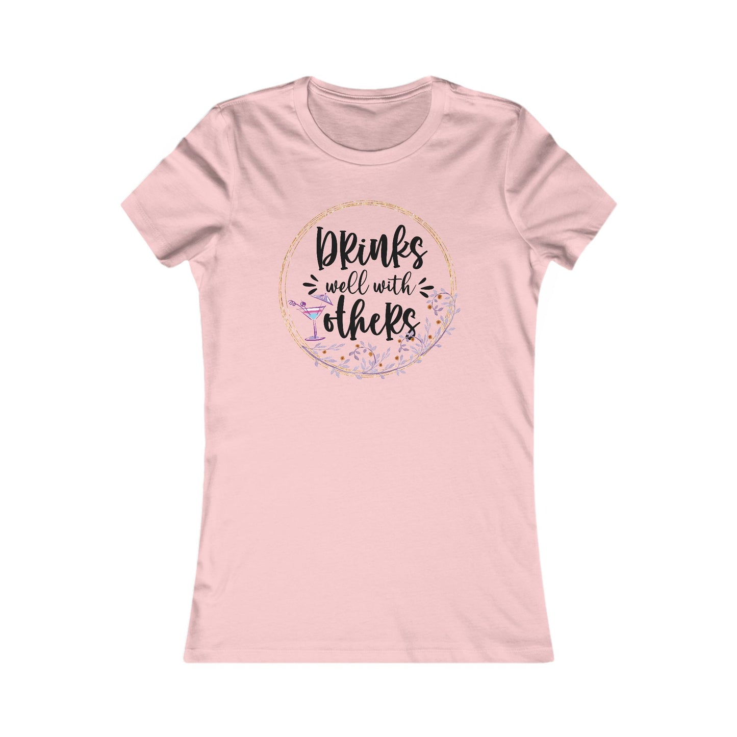 Elegant pink women's t-shirt featuring the phrase 'Drinks well with others' within a floral wreath design, complemented by a cocktail glass, ideal for casual gatherings.