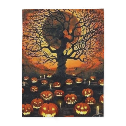 Decorative and Warm Halloween Spooky Arctic Fleece Blanket, beautifully illustrating an eerie landscape filled with grinning pumpkins and a haunting tree at dusk.