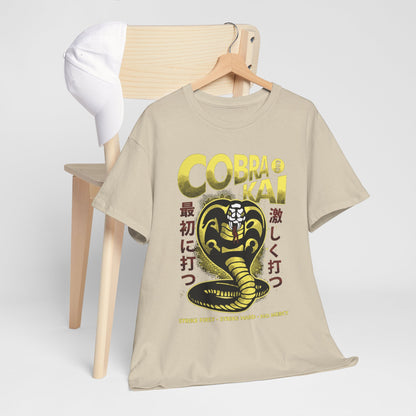 Impeccably styled Cobra Kai graphic T-shirt draped elegantly over a minimalistic chair, paired with a white cap, exuding casual luxury for every occasion.