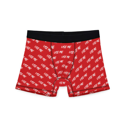 Cheeky red men's boxer briefs featuring the playful phrase 'USE ME' in white lettering, designed for a fun and romantic experience.