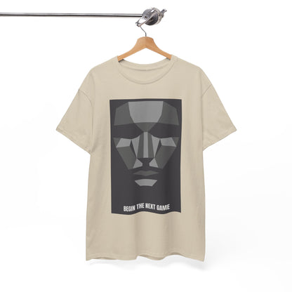 Chic beige unisex t-shirt displayed on a wooden hanger, highlighting a striking geometric face graphic and the phrase 'BEGIN THE NEXT GAME'.