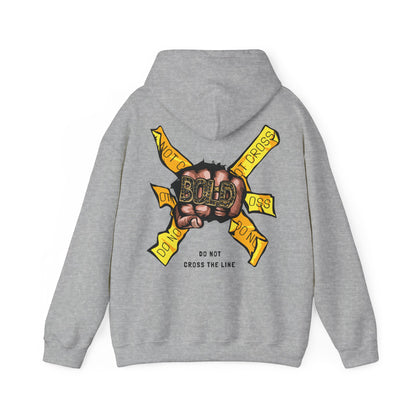 Chic grey hoodie showcasing an impactful design with a clenched fist and the word 'BOLD', enhanced by yellow tape saying 'DO NOT CROSS THE LINE'. Perfect for stylish individuals.
