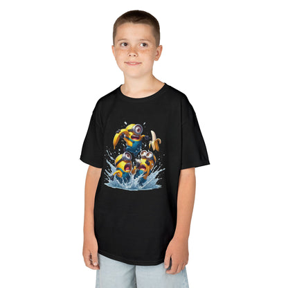A young boy smiling while wearing a Minions T-Shirt Kids Despicable Me Banana Yellow Graphic Tee. The t-shirt displays three lively Minions enjoying a splash in the water, making it a great fun choice for kids. T Shirt, Funny, Minions.