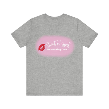 Sabrina Carpenter Inspired Unisex Short Sleeve Tee in chic heather grey, illustrating a vibrant lipstick design alongside the phrase 'Short 'n' sweet, I'm working Late...' for a modern, trendy look.