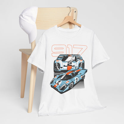 Stylish Porsche 917 graphic t-shirt displayed on a wooden chair, featuring iconic race car illustrations in vibrant blue and orange. Perfect for car enthusiasts seeking luxury and flair.