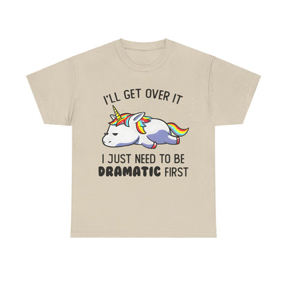 Unicorn Melancholy Graphic Tee featuring a whimsical cartoon unicorn in a dramatic pose, adorned with vibrant rainbow mane, accompanied by the humorous slogan 'I’LL GET OVER IT; I JUST NEED TO BE DRAMATIC FIRST'. Perfect for adding a touch of luxury and fantasy to your wardrobe.