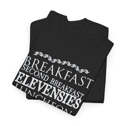Luxurious fold of black t-shirts showcasing the whimsical hobbit meal times in elegant white typography, an ideal gift for Tolkien enthusiasts.