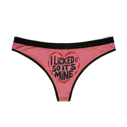 Front view of a stylish pink women's thong adorned with a bold heart graphic and the text 'I Licked It So It's Mine', ideal for romantic occasions.