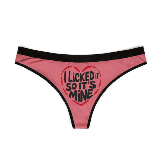 Front view of a stylish pink women's thong adorned with a bold heart graphic and the text 'I Licked It So It's Mine', ideal for romantic occasions.
