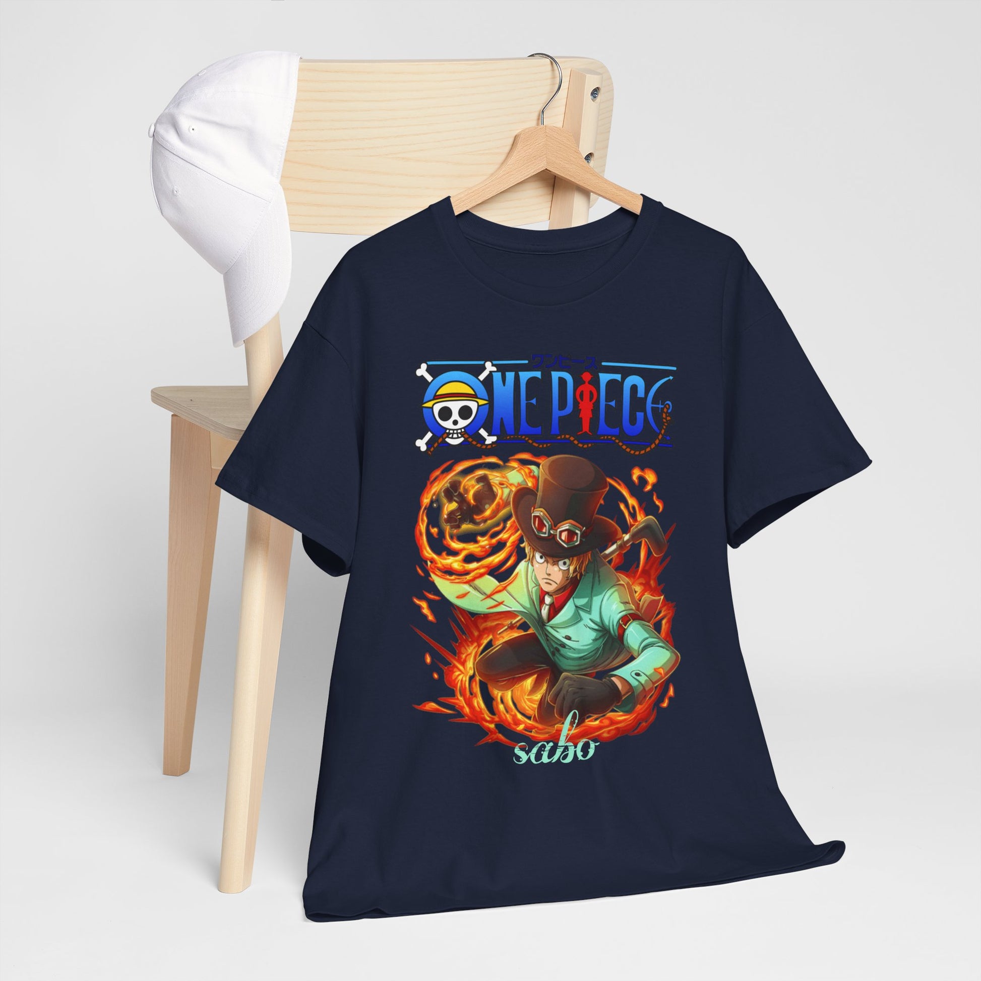 Chic navy t-shirt featuring Sabo from One Piece displayed on a wooden chair alongside a stylish cap, perfect for a fashionable anime-inspired outfit.