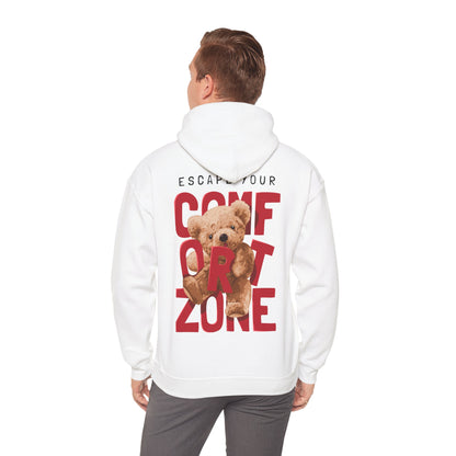 Man wearing a white hoodie with a striking teddy bear graphic and motivational text 'ESCAPE YOUR COMFORT ZONE' on the back, embodying playful luxury.