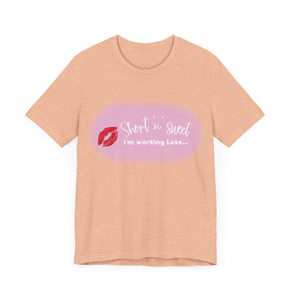 Front view of the exquisite Sabrina Carpenter Inspired Unisex Short Sleeve Tee featuring a vibrant lipstick design and whimsical text against a peach background.