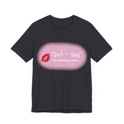 Premium Unisex Jersey T-Shirt in black displaying the playful phrase 'Short n sweet i'm working Late...' with kiss graphics, constructed from 100% cotton for superior softness.
