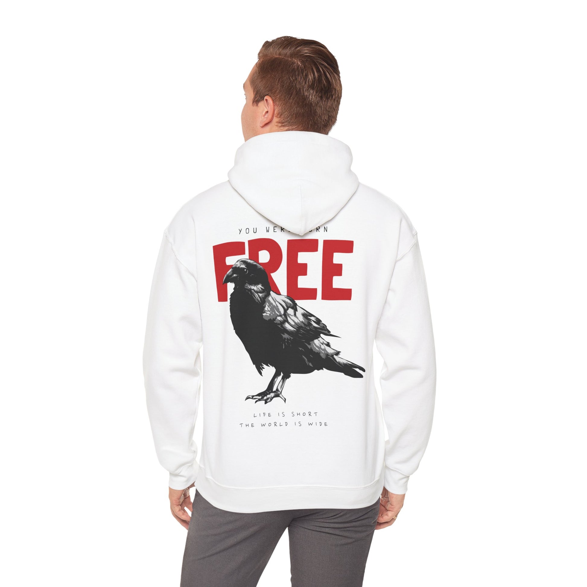 Man wearing a chic white hoodie with a striking raven graphic and bold typography that reads 'YOU WERE BORN FREE', exuding a sense of freedom and individualism.