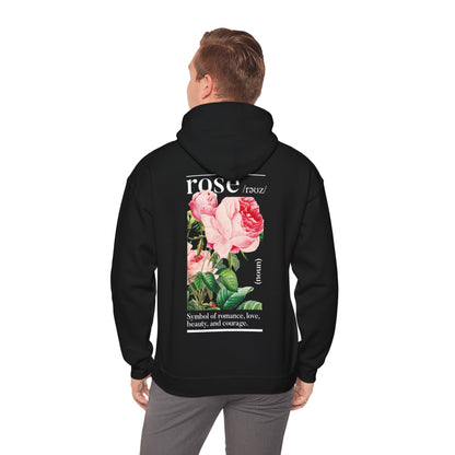 Sophisticated male model wearing a black hoodie with a vibrant botanical rose illustration on the back, embodying contemporary fashion aesthetics.